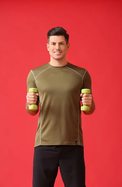 Joven Deportivo Entrenando Con Pesas Sobre Fondo Color —  Fotos de Stock