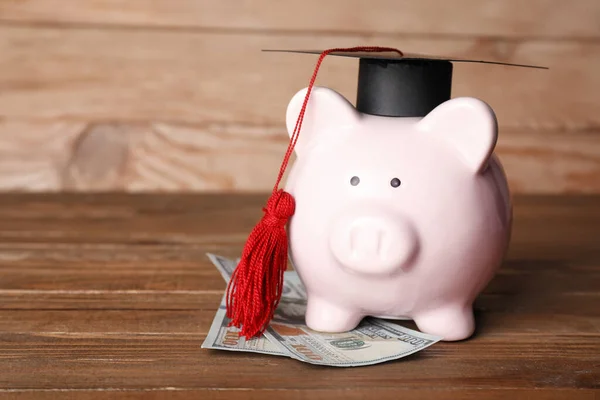 Sparschwein Mit Graduiertenmütze Und Dollarnoten Auf Holzgrund — Stockfoto