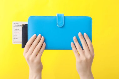 Renk arkaplanında seyahat düzenleyicisi olan kadın elleri