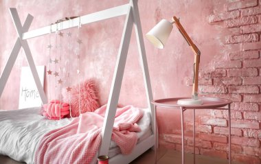 Modern çocuk odasının içinde şık bir yatak var.