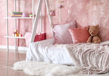 Modern çocuk odasının içinde şık bir yatak var.