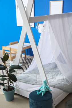 Modern çocuk odasının içinde şık bir yatak var.