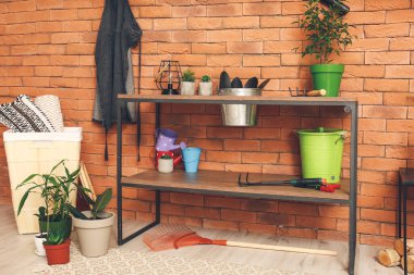 Ahırda farklı bahçe malzemeleri var.