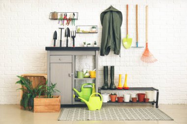 Ahırda farklı bahçe malzemeleri var.