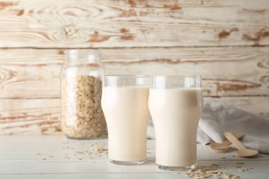 Hafif ahşap zemin üzerinde lezzetli yulaf sütü bardakları