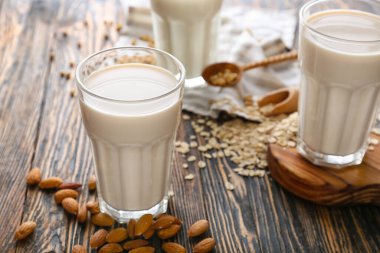 Koyu ahşap arka planda farklı vejetaryen sütleri.