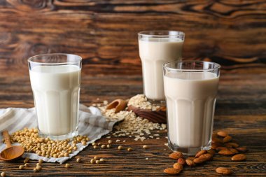 Koyu ahşap arka planda farklı vejetaryen sütleri.