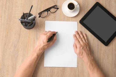 Erkek elleri ve tahta arka planda boş kağıt çarşaf