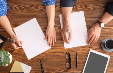 Ahşap zemin üzerinde boş kağıt çarşaflar olan eller