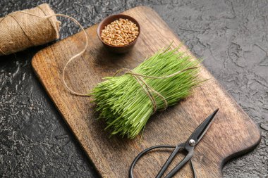 Taze buğday çimi, kasede tohumlar ve arka planda sicim.