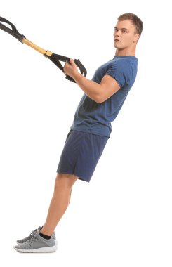 Beyaz arka planda TRX kayışları olan sportif genç adam eğitimi