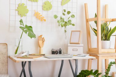 Odanın içinde ahşap elli ve çiçek desenli bir masa.