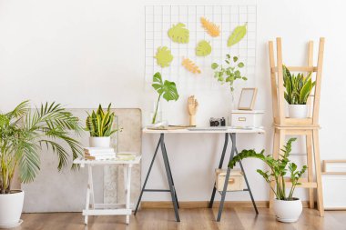 Odanın içinde ahşap elli ve çiçek desenli bir masa.