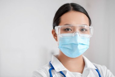 Klinikte tıbbi maske takan Asyalı kadın doktor portresi