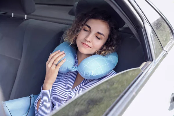 漂亮的年轻女子 带着旅行枕头睡在车里 — 图库照片