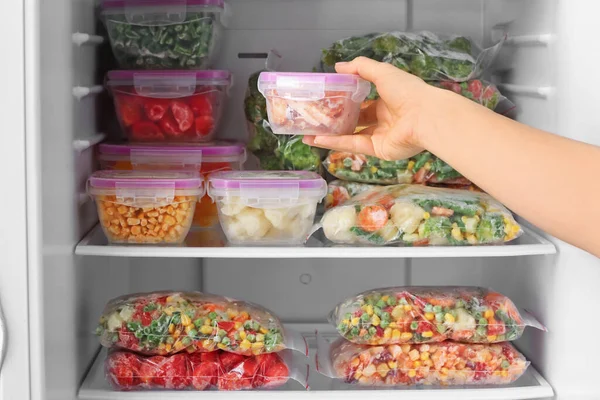 Woman Putting Container Frozen Vegetables Refrigerator — Stock Photo, Image