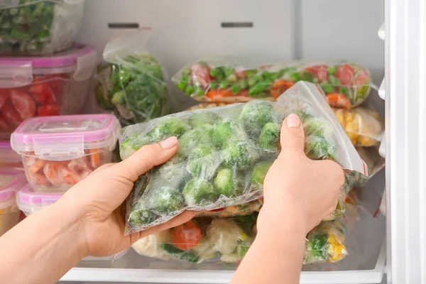 Wanita Menaruh Kantong Plastik Dengan Sayuran Beku Dalam Lemari — Stok Foto