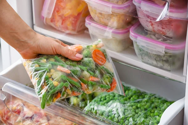 Woman Putting Plastic Bag Frozen Vegetables Refrigerator — Stock Photo, Image