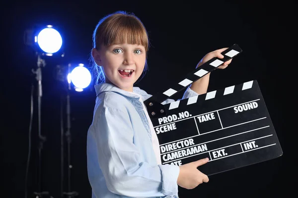 Kleines Mädchen Mit Filmklöppel Auf Dunklem Hintergrund — Stockfoto