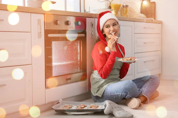 Young Woman Eating Tasty Homemade Gingerbread Cookies Kitchen Christmas Eve — Stock Photo, Image