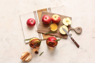 Baharatlı lezzetli bir içecek ve arka planda elma dilimleri.