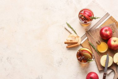 Baharatlı lezzetli bir içecek ve arka planda elma dilimleri.