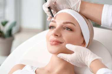 Güzellik salonunda kaş düzeltme ameliyatı olan genç bir kadın.