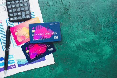 Renk arkaplanında belge ve hesap makinesi olan kredi kartları