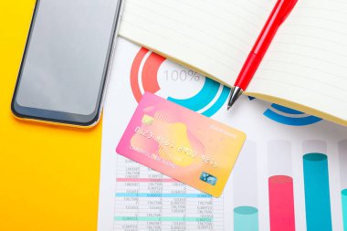 Renk arkaplanı üzerine kredi kartı, cep telefonu, belge ve defter