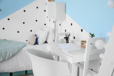 Modern çocuk odasının içinde şık bir masa var.