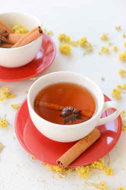 Tarçınlı lezzetli bitki çayı ve hafif arka planda fincanlarda anason.