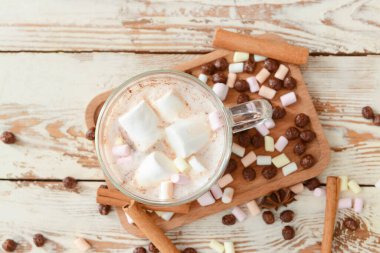 Tarçınlı lezzetli sıcak çikolata ve ahşap arka planda şekerleme.