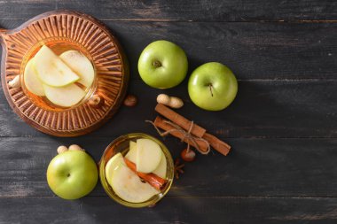 Koyu ahşap arka planda tarçınlı elma suyu.