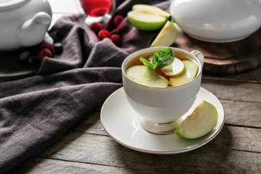 Elmalı sıcak çay ve ahşap zemin üzerinde nane.