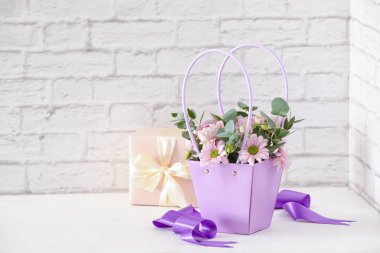 İçinde güzel çiçekler ve hediyeler olan sepet.