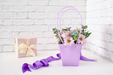 İçinde güzel çiçekler ve hediyeler olan sepet.