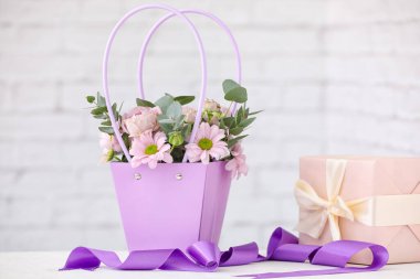 İçinde güzel çiçekler ve hediyeler olan sepet.
