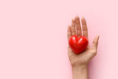 Renkli arka planda kırmızı kalpli el