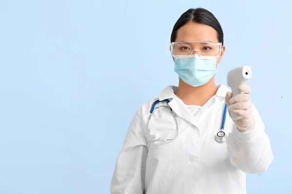 Porträtt Kvinnliga Asiatiska Läkare Med Infraröd Termometer Färg Bakgrund — Stockfoto