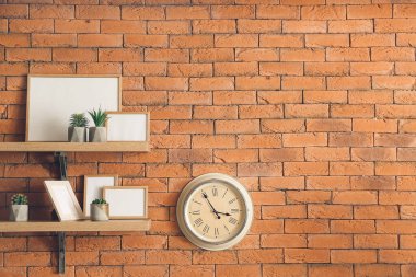 Tuğla duvarda dekor asılı saat ve raflar