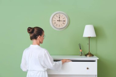 Genç bir kadın çekmeceleri açıyor.