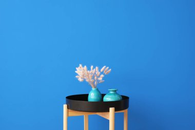 Renk duvarına yakın vazosu olan şık masa