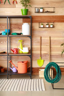 Ahırda farklı bahçe malzemeleri var.