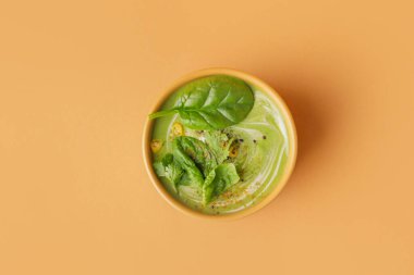 Arka planda lezzetli ıspanak çorbası olan bir kase.