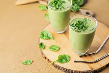 Renkli arkaplanda sağlıklı ıspanaklı smoothie bardakları