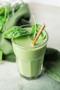 Arka planda bir bardak sağlıklı ıspanaklı smoothie.
