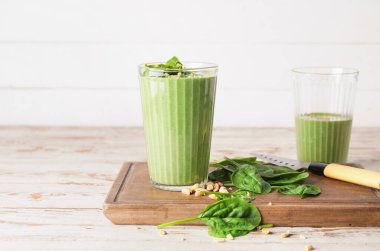 Tahta masada bir bardak sağlıklı ıspanaklı smoothie.