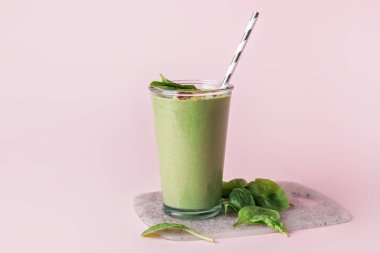 Arka planda bir bardak sağlıklı ıspanaklı smoothie.