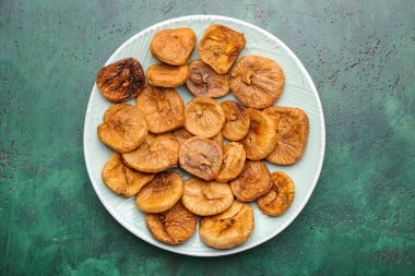 Renkli arkaplanda lezzetli kurutulmuş incir tabağı