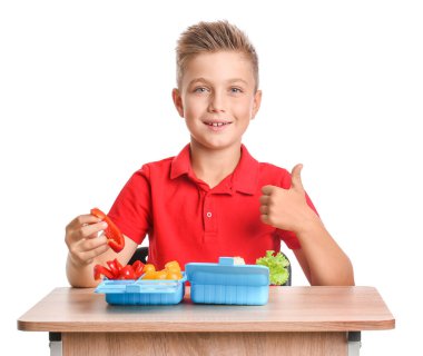 Masasında beyaz arka planda beslenme çantası olan öğrenci.